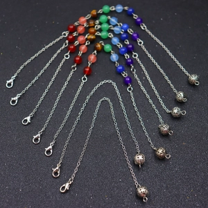 Detail of seven chakra crystal beads and hollow ball pendant on silver chain necklaces