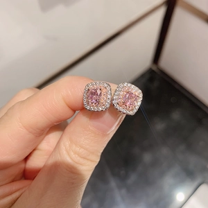 Detailed shot of pink cushion-cut zircon earrings set in rose gold with double diamond halo