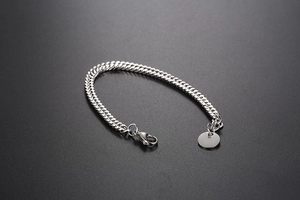 Detailed close-up of a silver stainless steel curb chain bracelet with lobster clasp