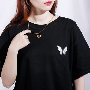 Elegant gold heart pendant necklace with twisted rope chain on model with black shirt