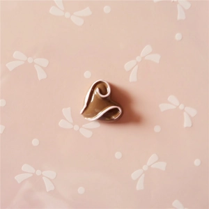 Detailed view of heart-shaped resin accessory with white swirls for DIY craft projects