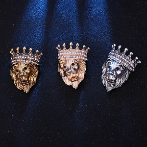 Regal lion head crown brooch in gold and silver finish with crystal inlay on black background