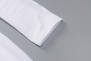 Detail shot of white long sleeve cuff showing premium knitted cotton and double-needle stitching