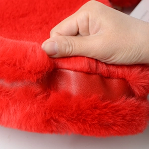 Detailed macro view showing the soft red faux fur texture and leather stitching of the bag