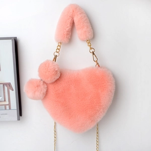 Detail showing the plush pink heart-shaped bag with soft faux fur texture and gold chain