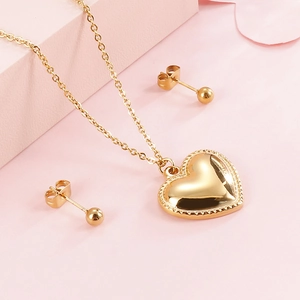 Set aus goldenem Edelstahl mit Herzanhänger Halskette und Ohrringen auf Rosa