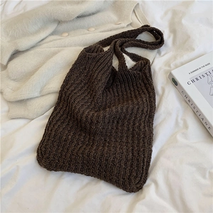 Dark brown woven tote bag with thick knit texture on a white background with a magazine