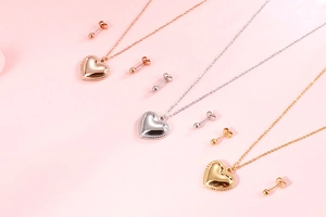 Set aus Herzanhängern und Ohrsteckern in Roségold, Silber und Gold in der Detailansicht