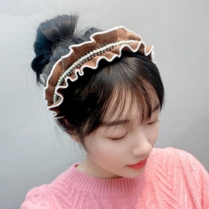 Detail of knitted headband with ruffled lace, faux pearls and rhinestone embellishments