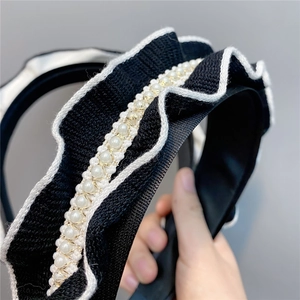 Macro detail of knit ruffle headband with pearl embellishments and golden wire weaving