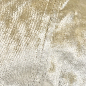 Macro view of champagne gold chenille fabric texture with neat double-stitched sewing detail