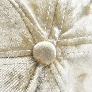 Close-up of beige chenille baseball cap top featuring velvet texture and center button