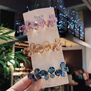 Three elegant crystal butterfly hair clips in purple, amber, and blue with shiny rhinestones