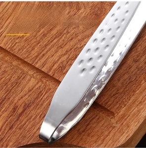 Macro detail of anti-slip stainless steel BBQ tongs handle with storage hook