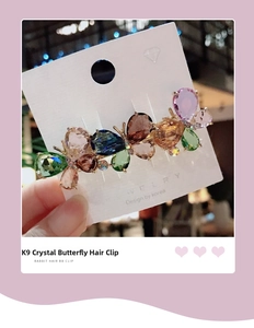 Macro shot of K9 crystal butterfly hair clip with colorful gemstones on a display card