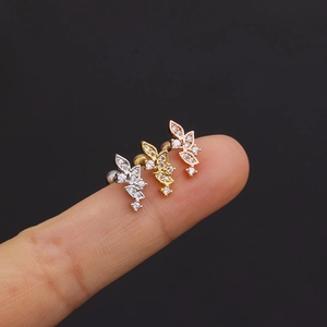 Close-up of three crystal-studded leaf stud earrings in silver, gold and rose gold colors