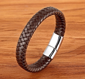 Men's braided leather bracelet with silver magnetic clasp on natural wooden background