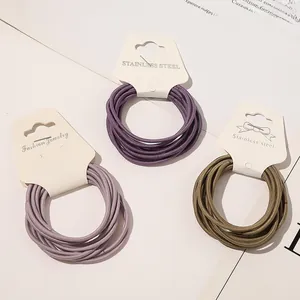 Detailed view of elastic hair ties in purple and olive green with stainless steel joints