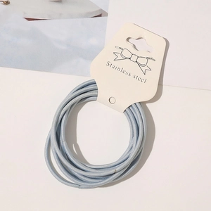 Detail of high-elastic light blue hair ties bundle on display card with textile texture