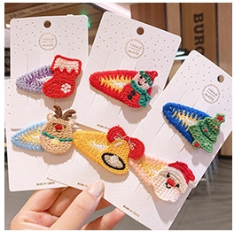 Close-up of handmade crochet Christmas hair clips with Santa, reindeer and tree motifs
