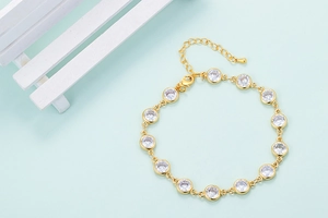 Close-up of gold chain bracelet with round-cut zircon stones and a secure lobster clasp