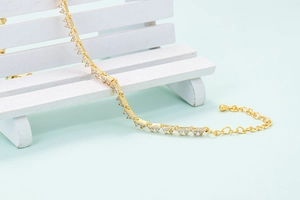 Detail of gold-plated geometric V-link bracelet featuring sparkling zircon micro-pave