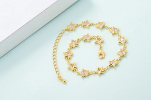 Detail of star-shaped gold chain with pink zircon stones and lobster clasp closure