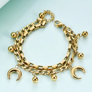 Macro shot of gold double-layer chain bracelet with crescent moon and bead charms