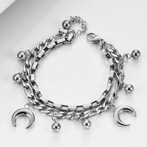 Detail of silver double-layered Cuban chain bracelet with moon pendants and metal beads