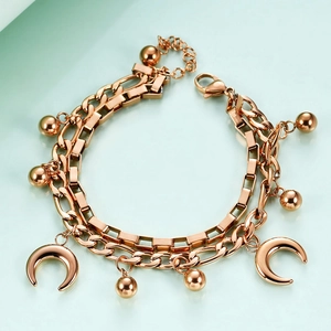 Detail of rose gold double layer Cuban chain bracelet with moon charms and ball beads