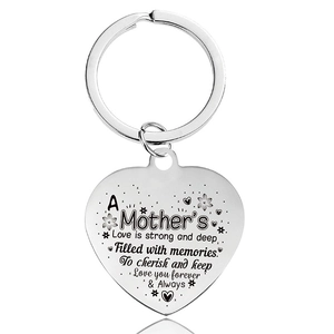 Detail of silver heart keychain with engraved 'A Mother's Love' poem on polished metal