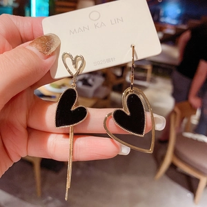 Detail of S925 silver needle asymmetric earrings with black velvet hearts and long tassels