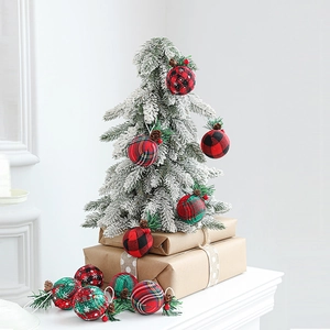 Red and green plaid Christmas ball ornaments with pine needles and cones on tree
