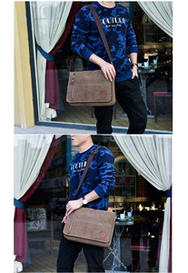 Close-up of brown canvas messenger bag showing front flap and zipper pockets in street setting