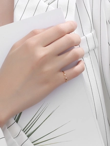 Detailed close-up of a minimalist gold open ring featuring two small round cubic zirconia
