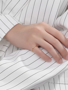 Close-up of minimalist gold S925 silver ring with double zircons worn on finger