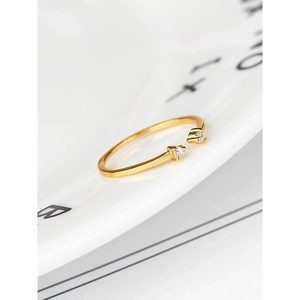 Macro shot of minimalist gold plated ring with dual cubic zirconia on a white plate