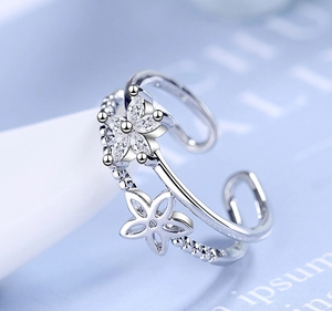 Macro detail of a double-layered open ring featuring zircon petals and hollow floral designs