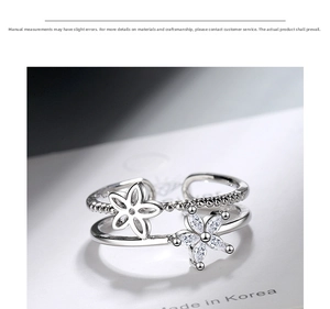 Detail of a double-layer open ring featuring sparkling zircon flower designs on white paper