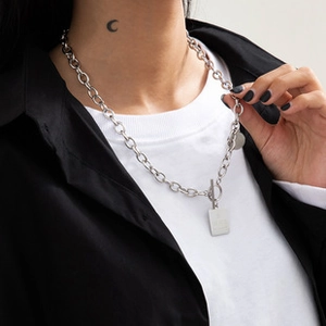 Detail of a silver double-layer star moon necklace with a rectangular dog tag and OT buckle
