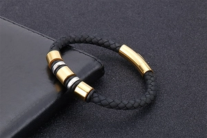 Detail of black braided leather bracelet with gold and silver beads and magnetic clasp