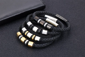 Detailed view of four braided black leather bracelets with various metallic clasps