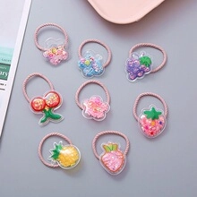 Detailed view of kids fruit hair ties with glitter-filled cherry and strawberry charms
