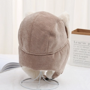 Close-up of cat ear winter hat made of brown corduroy and soft white faux fur trim