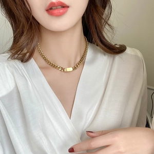 Elegant gold chunky chain necklace with rectangular pendant worn by a female model