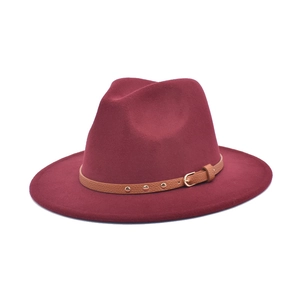 Detail of dark red wool felt jazz fedora featuring a brown leather band with metal studs