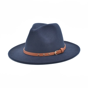 Detail view of dark blue wool fedora hat with brown leather band and metal buckle accent