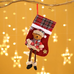 Detail eines Weihnachtsstrumpfs mit Plüschbär und goldenem Stern am Weihnachtsbaum