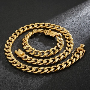 Macro shot of gold Cuban link chain set coiled on textured background with strong lighting