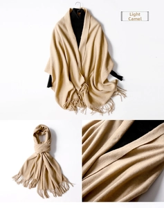 Detail of light camel wool scarf with elegant tassels and soft knitted texture details